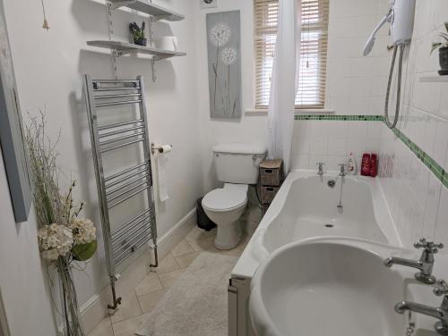 a bathroom with a tub and a toilet and a sink at Twenty Four in Hythe