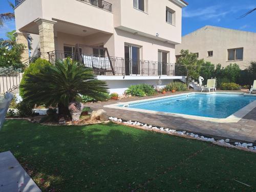 a villa with a swimming pool in front of a house at ROSE VILLA - 3 BED POOL in Episkopi Limassol
