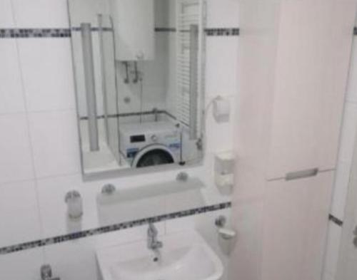 a bathroom with a sink and a mirror with a camera at TEA APARTMAN in Niš