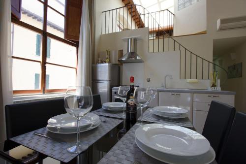 - une cuisine avec une table et des verres à vin dans l'établissement Santa Reparata Loft Florence, à Florence