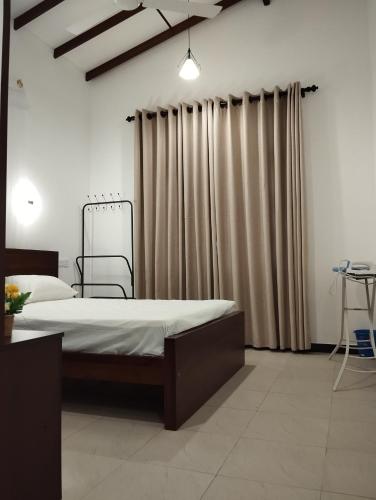 a bedroom with a large bed and curtains at Serene Bliss Villa in Unawatuna