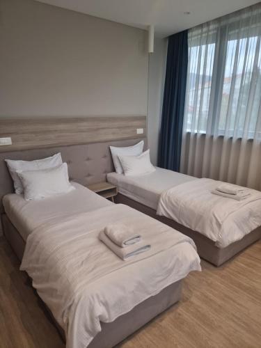 two beds in a hotel room with towels on them at Hotel Verso in Mostar