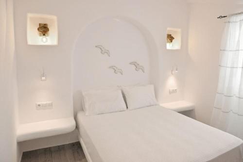 a white bedroom with a bed with white walls at Villa Areti Naxos in Glinado Naxos