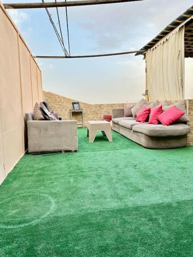 een woonkamer met een bank en groen tapijt bij stunning rooftop panoramic views in Caïro
