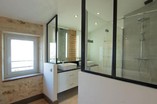 une salle de bain avec un lavabo et une douche en verre dans l'établissement Château Caillivet au cœur d'un vignoble Bio 14 personnes, à Mazères