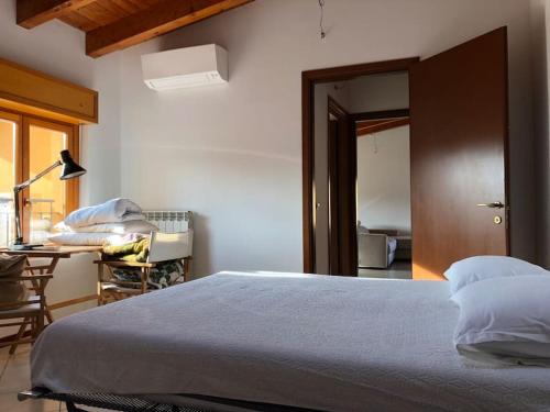 1 dormitorio con cama, escritorio y mesa en Mansarda Raffaello, en Seregno