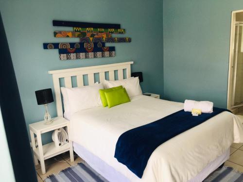 a bedroom with a white bed with a green pillow at Buxton lodge Guesthouse in Queenstown