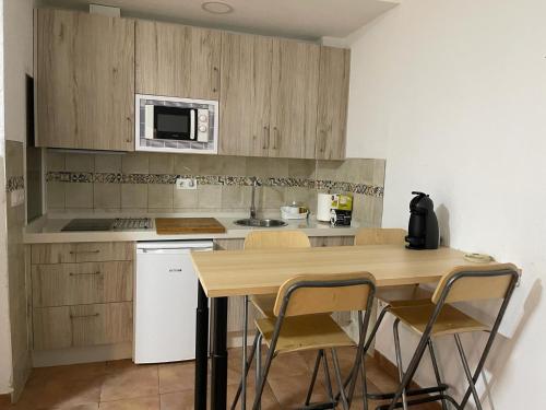 małą kuchnię z drewnianym stołem i krzesłami w obiekcie El apartamento de Ana -Jerez w mieście Jerez de la Frontera