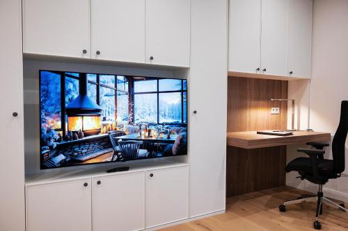 ein Wohnzimmer mit einem Flachbild-TV an der Wand in der Unterkunft Kleiner Rosengarten in Mannheim