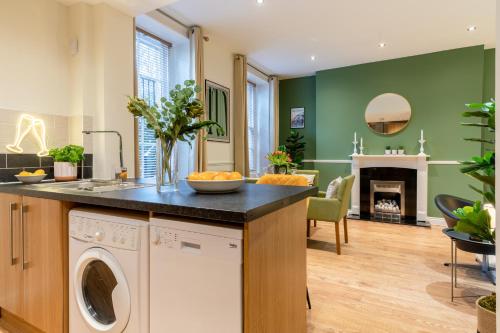 a kitchen and living room with a washer and dryer at Regency Basement Apartment in Cheltenham