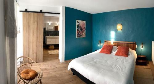 une chambre avec des murs bleus et un lit avec des oreillers rouges dans l'établissement *Villa Catalpas* Landaise, rénovée avec piscine, à Léon