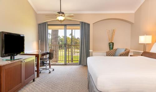 um quarto de hotel com uma cama, uma secretária e uma televisão em The Hotel at La Valle em Rancho Santa Fe