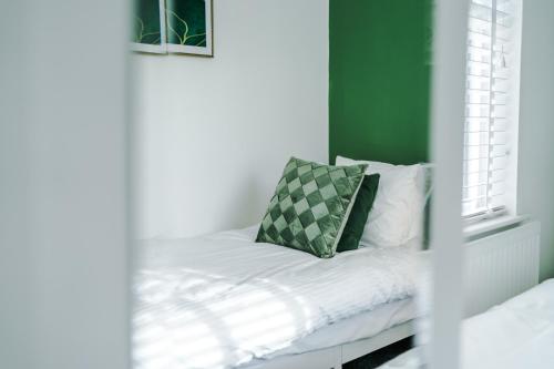 a bed in a room with a green wall at Large 7 bedroom town house in Chester City Centre in Chester