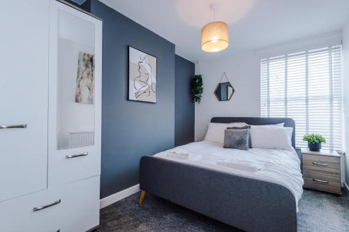 a bedroom with a bed and a blue wall at Large 7 bedroom town house in Chester City Centre in Chester