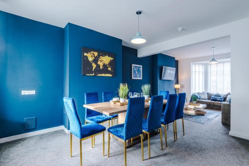 a dining room with blue walls and a table and chairs at Large 7 bedroom town house in Chester City Centre in Chester