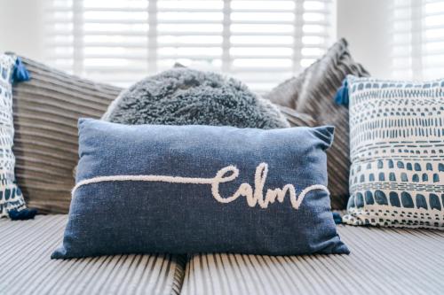 a blue pillow with the word calima sitting on a couch at Large 7 bedroom town house in Chester City Centre in Chester