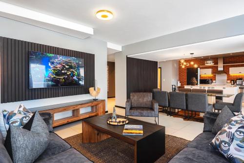 a living room with a couch and a dining room at CAG The Vantage Rosebank in Johannesburg