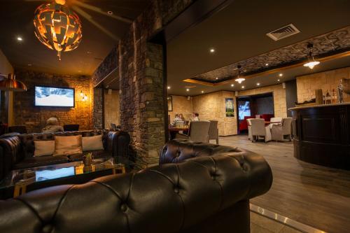 a lobby with leather couches and a bar with tables at Hotel Camellot by Nexta in Pas de la Casa