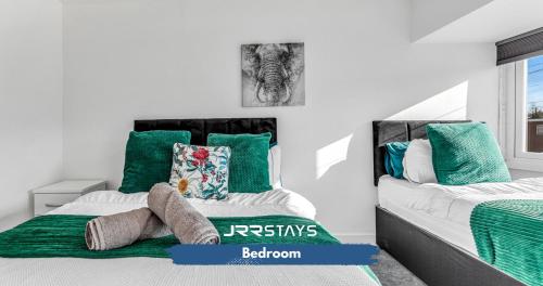 a bedroom with two beds with green and white pillows at Tipton 3 Bedroom House Garden Sleeps 7 - JRR Stays in Coseley