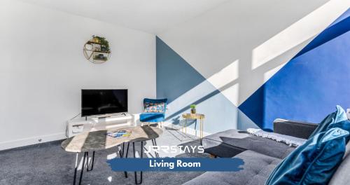 a living room with a tv and a blue wall at Tipton 3 Bedroom House Garden Sleeps 7 - JRR Stays in Coseley
