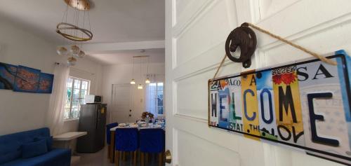 a room with a table and a sign on the wall at Casa de M&I in General Santos