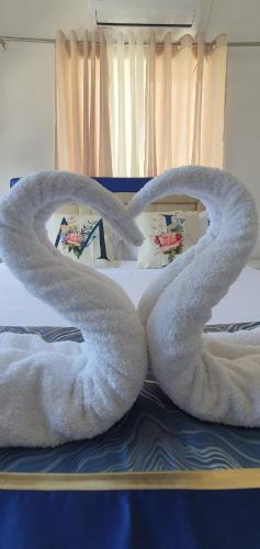 a pair of white towels on a bed at Casa de M&I in General Santos
