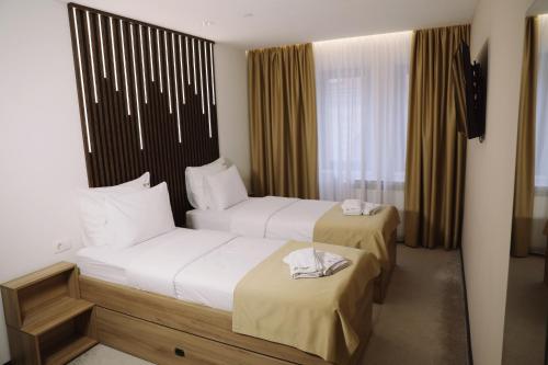 um quarto de hotel com duas camas com toalhas em Sax-Win em Pozega