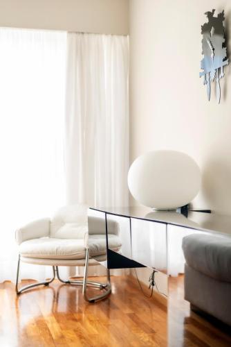 a living room with a white couch and a glass table at Hotel Aurora in Merano