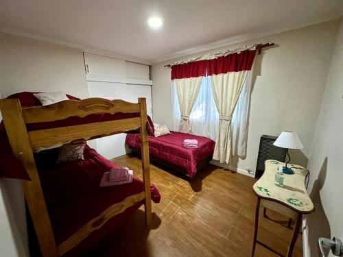 - une chambre avec 2 lits superposés et une table avec une lampe dans l'établissement AKAR USHUAIA, à Ushuaia