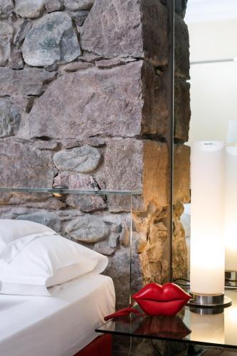 a bedroom with a stone wall and a glass table at Hotel Aurora in Merano