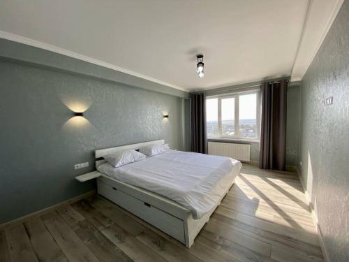 a bedroom with a bed and a large window at Family Haven Apartment in Chişinău
