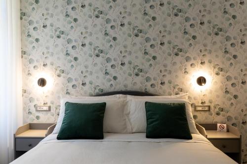 um quarto com uma cama branca e almofadas verdes em Damatti Room em Messina