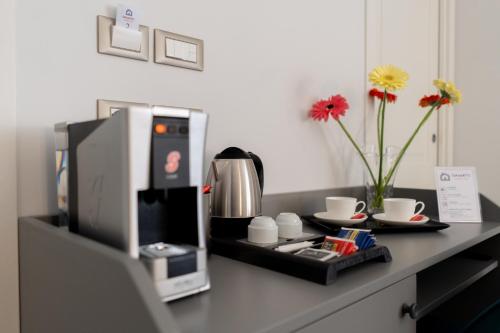 a counter with a microwave and cups and flowers on it at Damatti Room in Messina