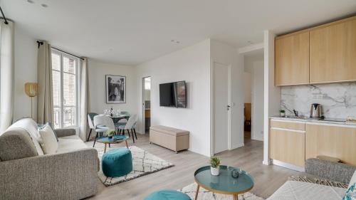 uma sala de estar com um sofá e uma mesa em 153 Suite Mylene - Superb apartment in Paris em Paris