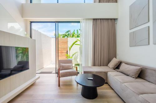 a living room with a couch and a table at Oasis Smart Villa 3 Canggu in Canggu