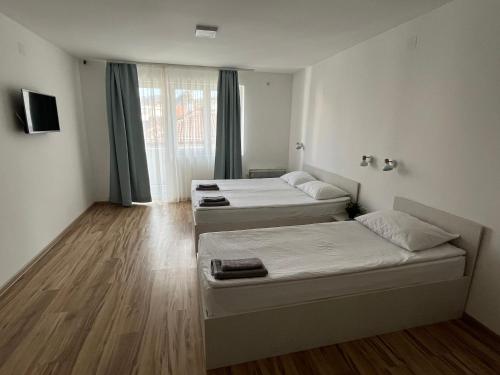 a room with three beds and a window at Smeštaj Milutinn in Soko Banja