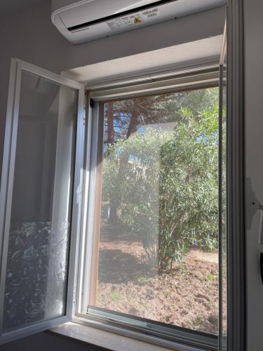 a window with a view of a garden at Alba Majore beach apartment in Rena Majore