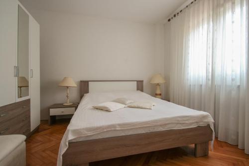 een slaapkamer met een bed met 2 kussens erop bij Martinis A4 in Novigrad Istria