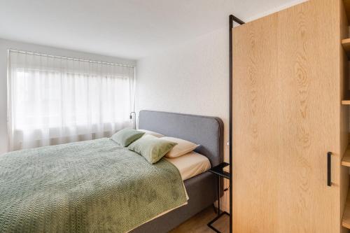 um quarto com uma cama e uma janela em Bijou Sternen - Bergluft und Seeträume em Faulensee