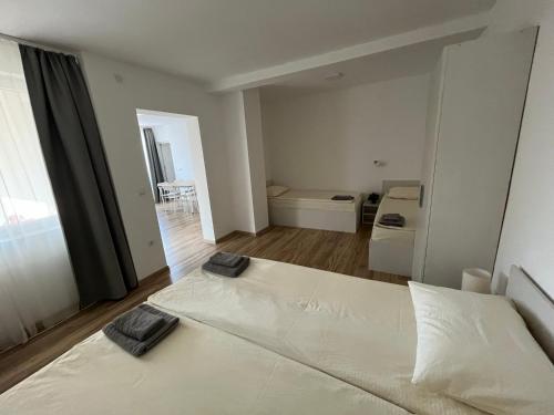 a bedroom with a large white bed with two pillows on it at Smeštaj Milutinn in Soko Banja