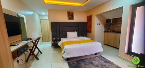 a hotel room with a bed and a television at Homegate Resort in Lekki