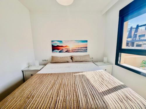 a large bed in a room with a large window at Apto Higuericas playas in Pilar de la Horadada