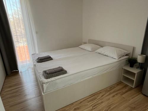 a white bed with two towels on it in a room at Smeštaj Milutinn in Soko Banja