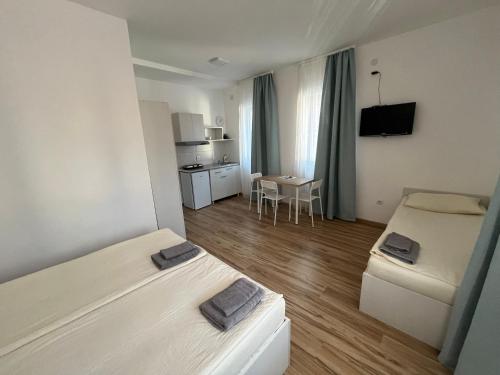 a small room with two beds and a table at Smeštaj Milutinn in Soko Banja