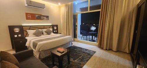 a hotel room with a bed and a couch at رفان للشقق المخدومة in Khamis Mushayt