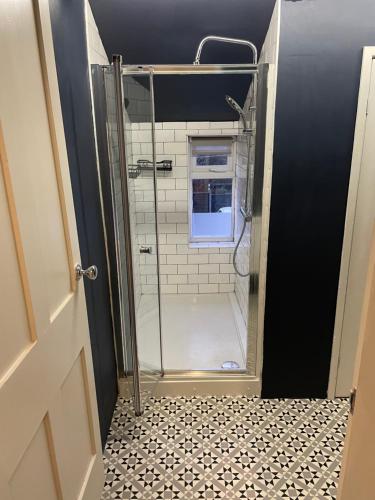 a shower with a glass door in a bathroom at 48 South St in Alderley Edge