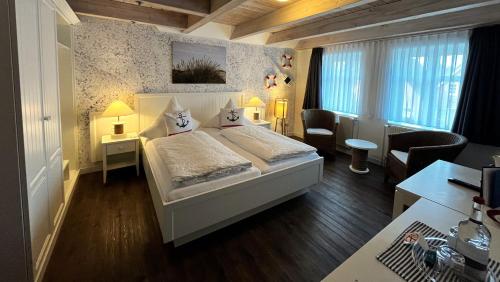 ein Schlafzimmer mit einem großen weißen Bett in einem Zimmer in der Unterkunft Hotel Anka in Norddorf