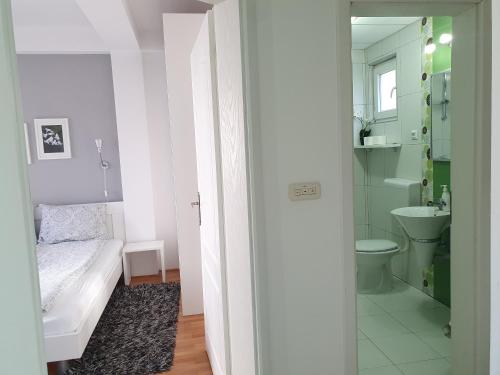 uma pequena casa de banho com uma cama e um lavatório em Apartments Nela em Ohrid