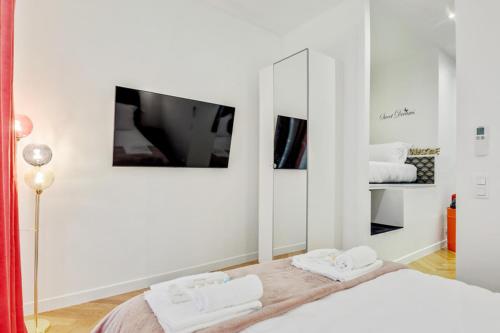 Habitación blanca con cama y espejo en 206 Suite Hermès - Superb apartment in Paris, en París