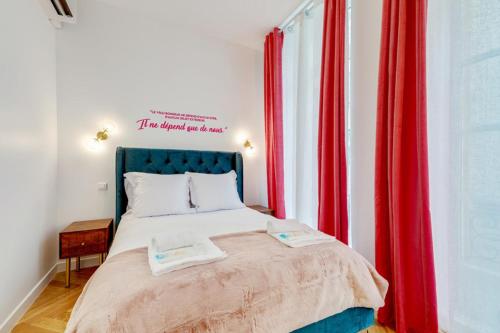 1 dormitorio con cortinas rojas y 1 cama con 2 toallas. en 206 Suite Hermès - Superb apartment in Paris, en París